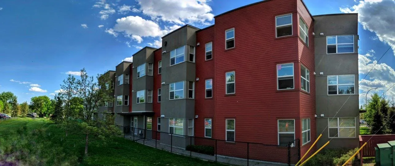 Inglewood House seen from the side, with its red and grey walls and a wide lawn