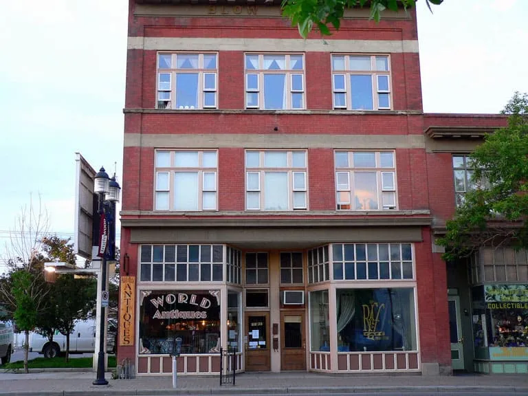 A historic red-brick building with bay windows and an antiques shop on Inglewood’s 9th Avenue