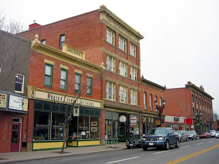 Colourful heritage storefronts and a tall brick building on 9th Avenue
