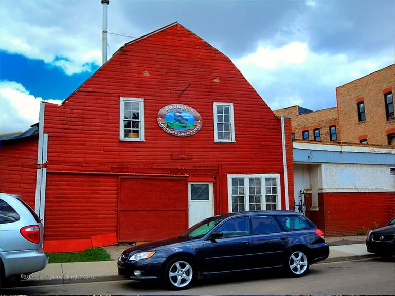 A bright red barn-style building with cars parked in front, in Inglewood