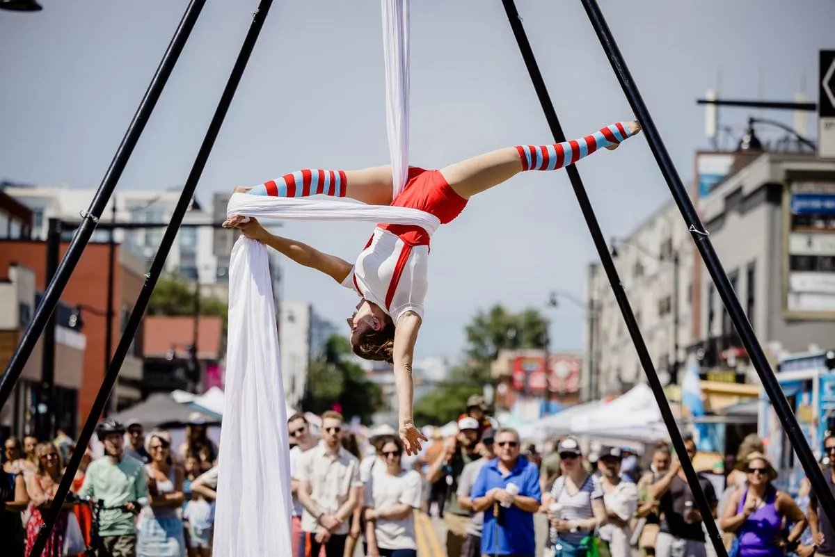 An aerial performer on silks above a crowd at Inglewood Sunfest on 9th Avenue
